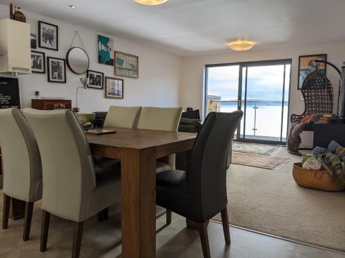 a dining room with a wooden table and chairs at Panoramic sea views, sleeps 4, Torquay in Torquay