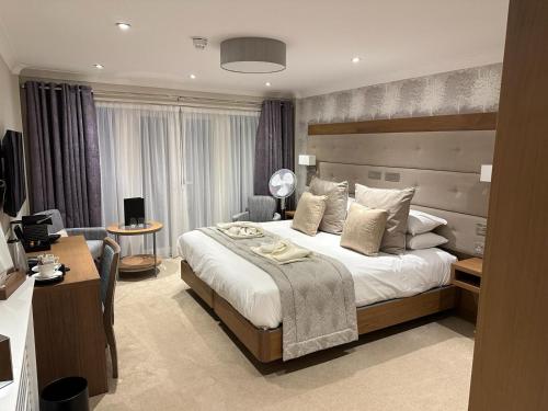 um quarto de hotel com uma cama grande e uma secretária em The Fig Tree Hotel em Shanklin