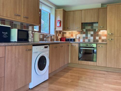 a kitchen with a washer and dryer in it at Water Mill Vacations Badgers Oak - Pet Friendly in Newport