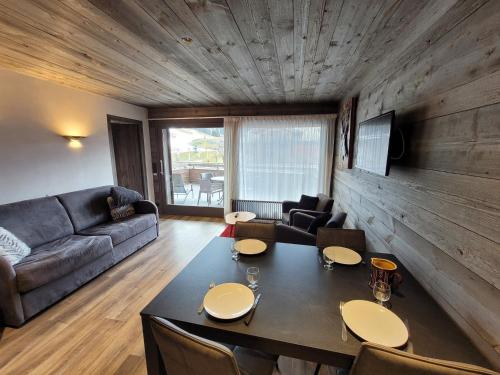 un salon avec une table et un canapé dans l'établissement Charmant T2 près pistes, Les Gets, balcon, parking, wifi - FR-1-598-135, aux Gets