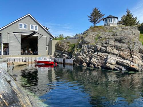 una casa y un barco en un cuerpo de agua en House by sea - Bergen, Norway. Free boat. en Askøy