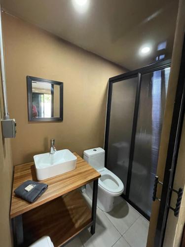 ein Bad mit einem Waschbecken und einem WC in der Unterkunft OHANA HOTEL & VILLA in Tierra Blanca