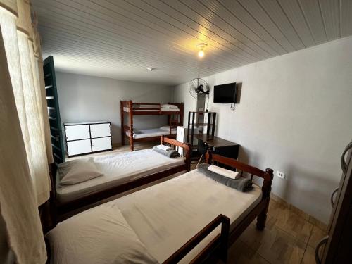 um quarto com duas camas e uma televisão em Family Hostel em São Paulo