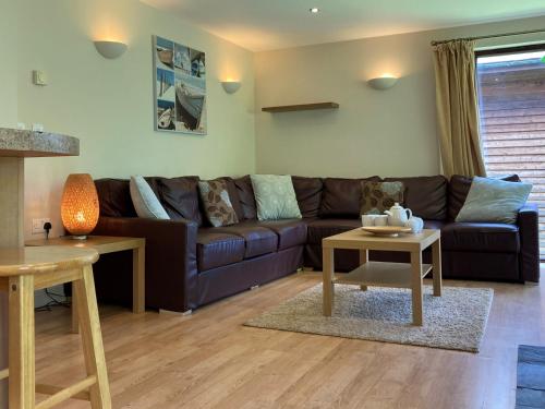 a living room with a brown couch and a table at Water Mill Vacations Kingfisher in Newport