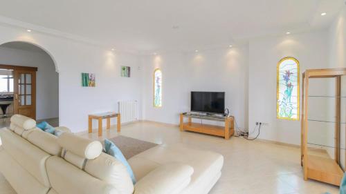 a living room with a white couch and a tv at Villa María de Periana by Ruralidays in Periana