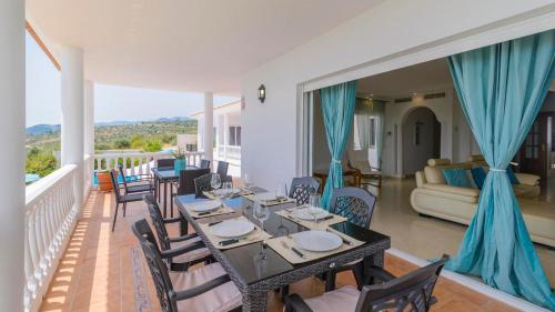 a dining room with a table and chairs on a balcony at Villa María de Periana by Ruralidays in Periana