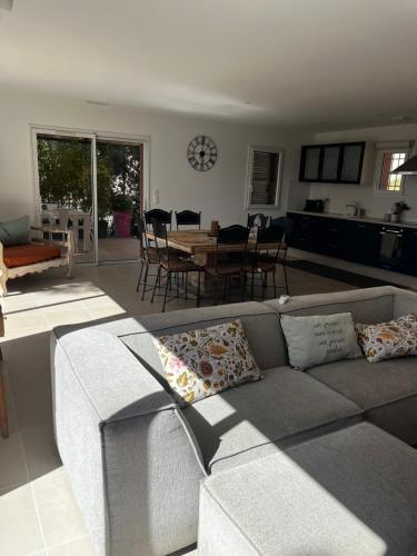 ein Wohnzimmer mit einem Sofa und einem Tisch in der Unterkunft La villa Rosa in Bédoin
