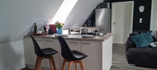 a kitchen with two black chairs at a counter at Ferienwohnung Nietwerder in Nietwerder