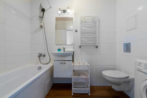 uma casa de banho branca com um WC e um lavatório em Quiet 3-bedroom flat. Old town. em Varsóvia