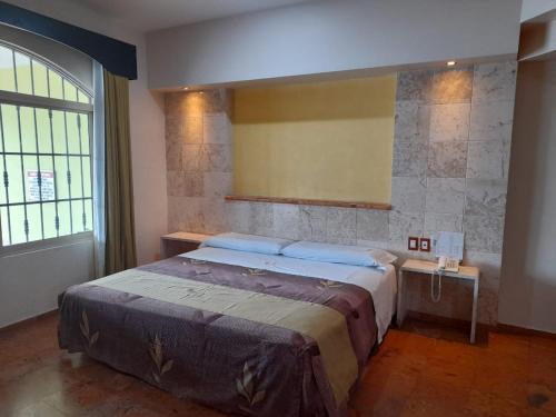 1 dormitorio con cama y ventana grande en HOTEL A´PONTE, en Mérida