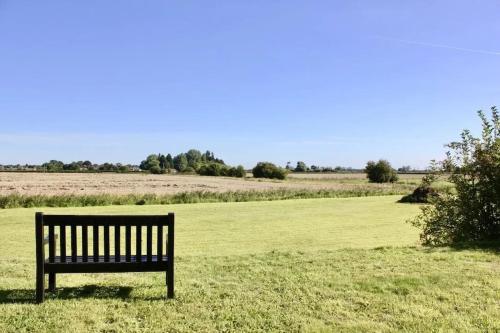 a bench sitting in the middle of a field at Luxe Glamping In A Tiny Home, Adults Only, Dogs Allowed in Lincolnshire