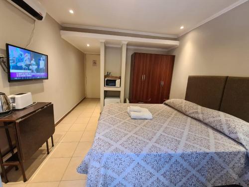 a bedroom with a bed and a tv on the wall at Hotel Firenze in Necochea