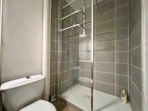 uma casa de banho com um WC e uma cabina de duche em vidro. em Appartement 2 prsn / Proche Centre-Ville em Besançon