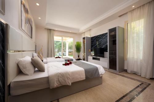 a bedroom with a large bed and a flat screen tv at Zyra Luxury villa with pool and Jacuzzi in New Cairo in Cairo