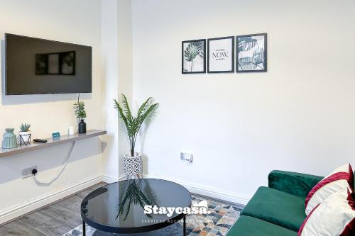 a living room with a green couch and a glass table at Stylish Ensuite Room - Superfast Wi-fi 250mbps in Manchester