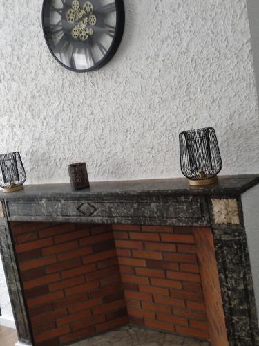 a brick fireplace with a clock on the wall at Bienvenue chez Coco in Dunkerque
