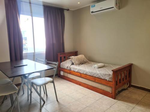 a bedroom with a bed and a table and a dining room at Hotel Firenze in Necochea
