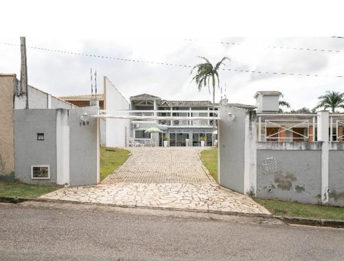 ein großes weißes Gebäude mit einer Palme davor in der Unterkunft Quarto com suite e ar condicionado localizado em um condomínio fechado. in Itatiba