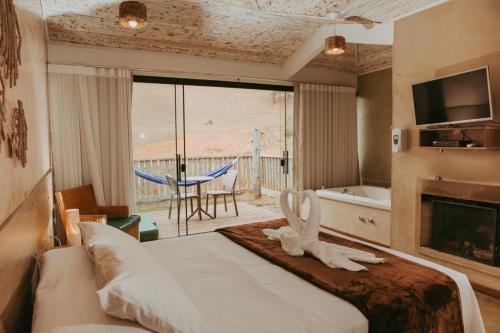 a bedroom with a bed and a view of a patio at Hotel Fazenda Cheiro Verde in Mercês