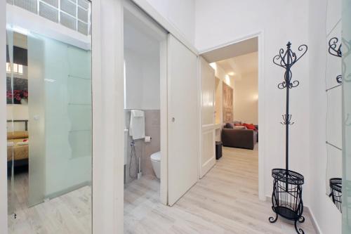 a bathroom with a toilet and a room with a couch at Domus Monamì Apartment in Rome