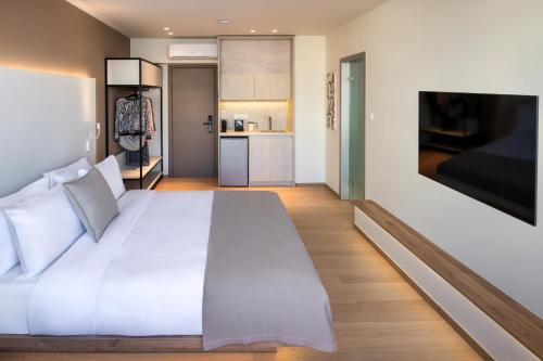a bedroom with a large white bed and a kitchen at Pelagus City - Luxury Suite II in Thessaloniki