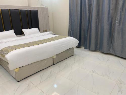 ein großes Bett in einem Schlafzimmer mit weißem Boden in der Unterkunft بيست تريب فالنسيا in Dschāzān