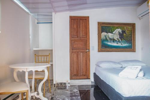 um quarto com uma cama e uma pintura de um cavalo em Hotel La Casona de Getsemani em Cartagena das Índias