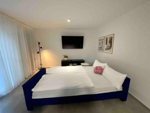 a bedroom with a large bed with a pink pillow on it at DaCasa-Appartement: zentral/SmartTV/24h Check in in Tamm