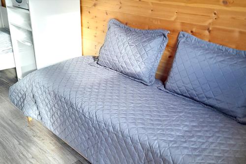 a bed with a blue comforter and two pillows at Campsie Glen Holiday Park in Glasgow