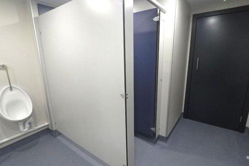 an empty bathroom with a urinal and a door at Campsie Glen Holiday Park in Glasgow