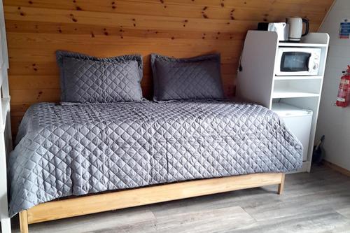 a bed in a bedroom with a wooden wall at Campsie Glen Holiday Park in Glasgow