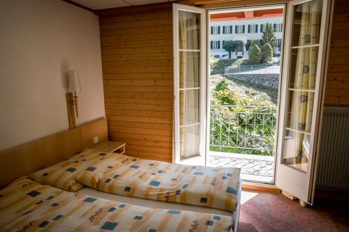 a bedroom with a bed and an open door at Hotel Alpenhof in Kerns