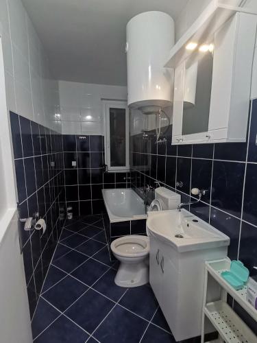 a bathroom with a white toilet and a sink at Eiffel tower Niksic in Nikšić