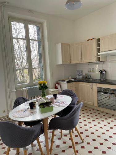 uma cozinha com uma mesa e cadeiras e uma mesa e uma cozinha em Appartement 1er étage Villa Isabelle em Allevard