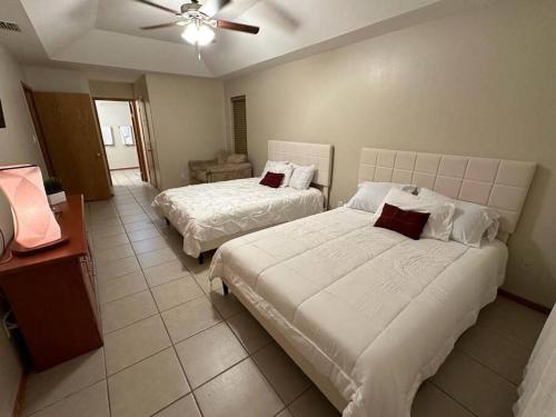 a bedroom with two beds and a ceiling fan at McAllen 4BR with Pool, Shopping & More in McAllen