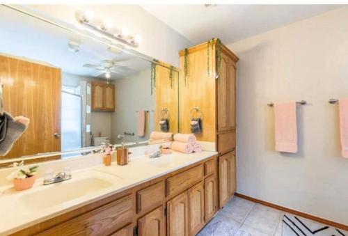 a bathroom with a sink and a large mirror at McAllen 4BR with Pool, Shopping & More in McAllen