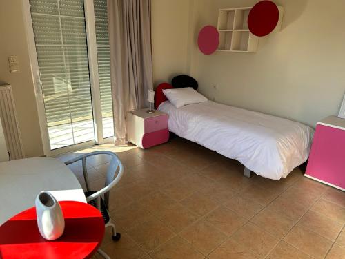 a room with two beds and a table and chairs at Villa Ariadni in Patra