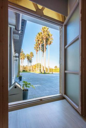 an open window with palm trees in the background at Hotel La Palma de Llanes in Llanes