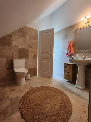 une salle de bain avec toilettes, lavabo et miroir dans l'établissement La Perchonniere, à Mamers