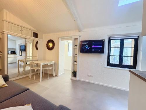 un salon avec un canapé et une télévision sur un mur dans l'établissement Joli studio Cannes marché forville, à Cannes
