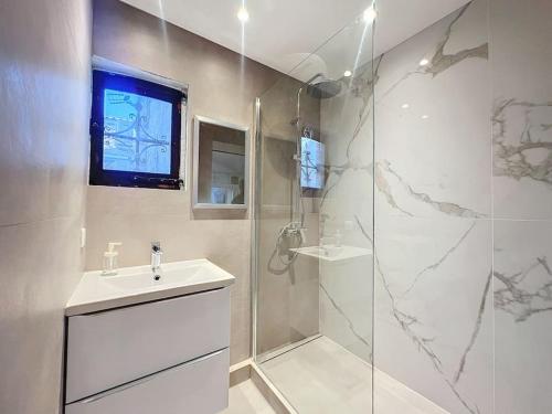 une salle de bain blanche avec une douche et un lavabo dans l'établissement Joli studio Cannes marché forville, à Cannes
