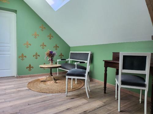 a room with two chairs and a table and a piano at La Perchonniere in Mamers