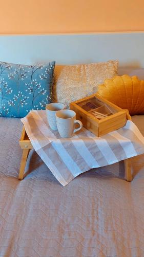 two coffee cups and a tray on a bed at La casa del Mago camere e appartamenti in Pissignano