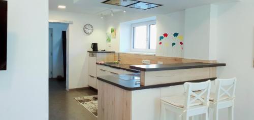 cocina con encimera y 2 sillas blancas en 3-Zimmer- Wohnung in Traun, nähe Linz und Wels, en Linz