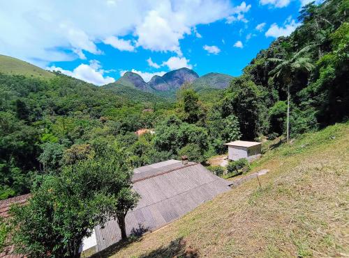 a house on a hill with mountains in the background at Casa Fofa! No Coração de Araras! in Araras Petropolis