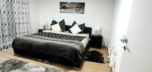 1 dormitorio con cama con sábanas y almohadas negras en 3-Zimmer- Wohnung in Traun, nähe Linz und Wels, en Linz