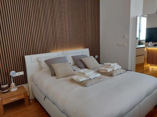 Un dormitorio con una cama blanca con toallas. en Loft del Talvera 2, en Bolzano
