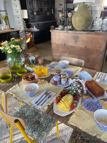 a table topped with plates of food and fruit at Quinta Baltazar Casa particular in Vila Nova de Cacela