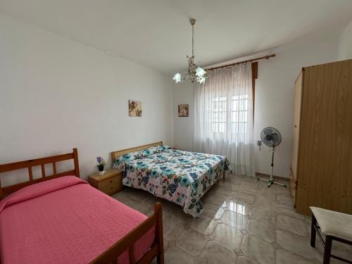 Un dormitorio con una cama, una mesa y un ventilador. en Villa Posillipo, en Marina di Mancaversa