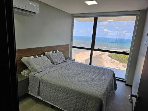 - une chambre avec un lit et une vue sur la plage dans l'établissement Flat #2506 BARRA HOME STAY, à Récife